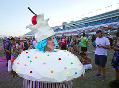 a woman in a cupcake costume at a music festival with other people around her