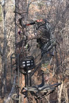 a man standing on top of a tree stand