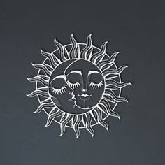 a paper cut sun and moon face on a gray background