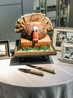 there is a cake with a turkey on it and two framed pictures next to it