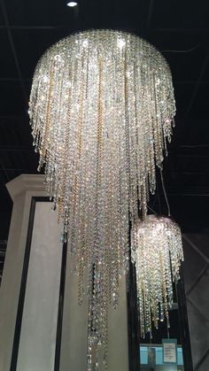 a large chandelier hanging from the ceiling in a room with mirrors and lights