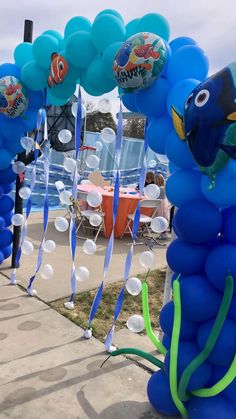 some blue balloons with fish on them and streamers in the shape of sea animals