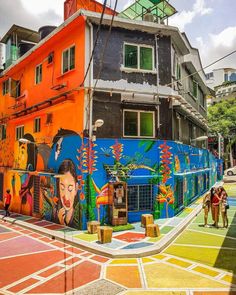 people are standing in front of a colorful building