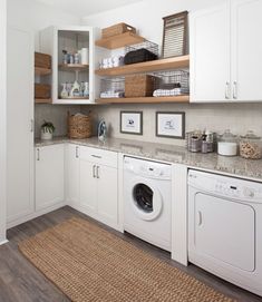 a washer and dryer in a white laundry room with open shelving on the wall