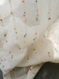 a white curtain with multi colored dots on it