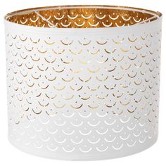 a white and gold candle holder with circles on the bottom, in front of a white background