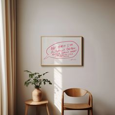 a room with a chair, potted plant and a sign hanging on the wall