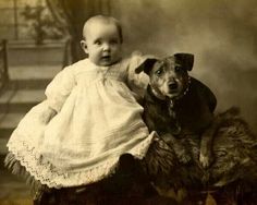 an old photo of a baby and a dog