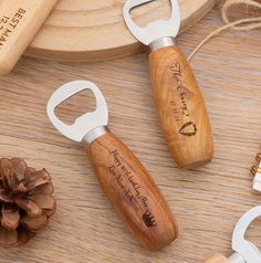 two bottle openers sitting next to each other on top of a wooden table with pine cones