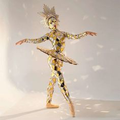 an artistically designed figure is standing in front of a white background with gold and black designs