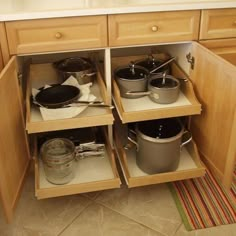 an open cabinet with pots and pans in it