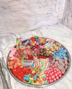 a platter filled with candy and candies on top of a marble countertop