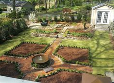 an aerial view of a small garden with a fountain in the center and landscaping around it