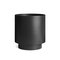 a black cup sitting on top of a white surface