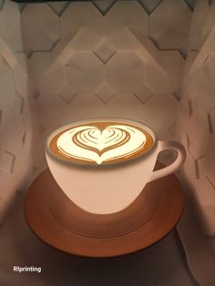 there is a coffee cup with a heart in the foam on it's top