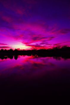 a purple and pink sunset over a lake