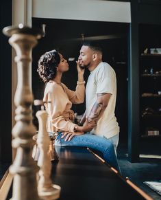 a man and woman sitting at a table talking to each other while looking into each others eyes