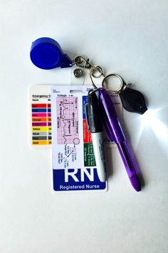 a purple pen and some keys on a white surface