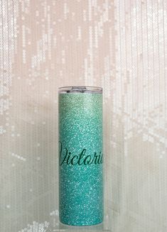 a blue and green tumbler with the word victoria on it