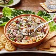 a bowl of chicken salad with crackers on the side