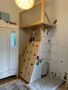 a loft bed with a climbing wall and ladder to the top is made out of plywood