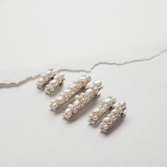 "Delicate barrettes for your flower girls and young bridesmaids. Small and dainty clusters of freshwater pearls attached to silver alligator barrettes. Sold as a pair and available in three sizes. The smallest size is ideal for children under the age of two. They are quite dainty. Each barrette is lined with grosgrain ribbon for a comfortable fit and the pearls are wired by hand. SIZE S - 0.9\" M - 1.3\" L - 1.9\" MADE TO ORDER Production time varies, please see estimated shipping date. For rush orders, please send us a message. CARE Store in cool dry place. Treat tarnish with metal polish." Pearl Barrette, Holiday Wrapping Paper, Flower Girl Hairstyles, Pearl Cluster, Pearl Hair, Flower Girls, Wedding Hair Accessories, My Flower, Grosgrain Ribbon