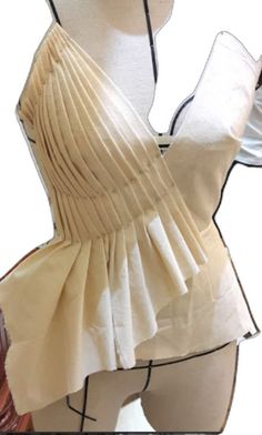 a mannequin wearing a white top with ruffles on it