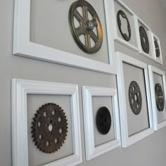 there are many framed pictures on the wall with gears attached to each one, all in white frames