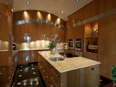 a modern kitchen with marble counter tops and stainless steel appliances, along with wooden cabinets