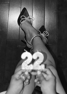 two people are holding up the number twenty one in front of their feet and wearing high heels