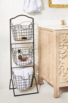 a bathroom with two baskets on the wall and a towel rack in front of it