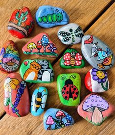 painted rocks are arranged on a wooden surface