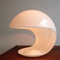 a white lamp sitting on top of a wooden table