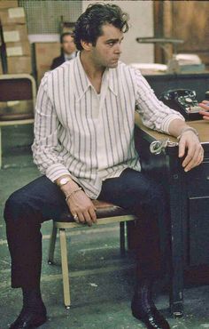 a man sitting in a chair next to a desk