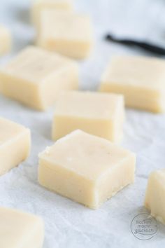 several pieces of white chocolate sitting on top of wax paper