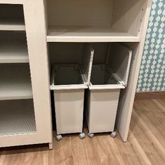 two white bins sitting in the middle of a bookcase next to each other