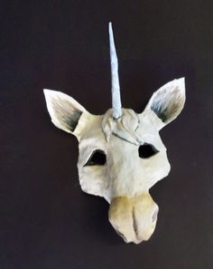 an animal's head is made out of white paper and has a horn on it