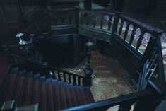 an old staircase with wooden handrails and red carpeted flooring in a dark room