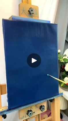 an easel with a blue painting on it