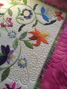 a close up of a quilt with flowers on it