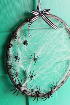 a glass plate with spider webs on it and a bow hanging from the top