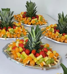 fruit platters with pineapples, strawberries, oranges and grapes