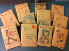 many small books with writing on them are lined up next to each other and have hearts drawn on them