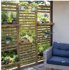 a chair sitting on top of a patio next to a planter filled with potted plants