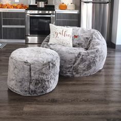 a living room filled with furniture and a metal stove top oven next to a kitchen