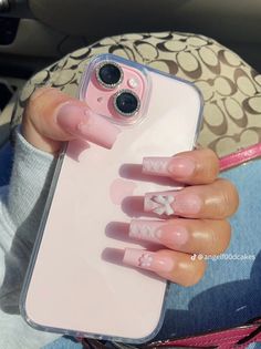 a person holding a cell phone case with pink nails on it and an iphone in the other hand