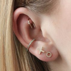 a close up of a person wearing two different types of ear piercings on their ears