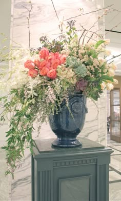 a blue vase filled with flowers on top of a table