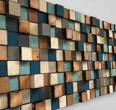 a wall made out of wooden planks with blue and brown squares on the side