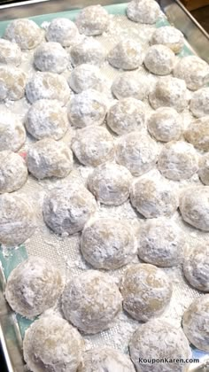 a baking sheet covered in powdered sugar cookies